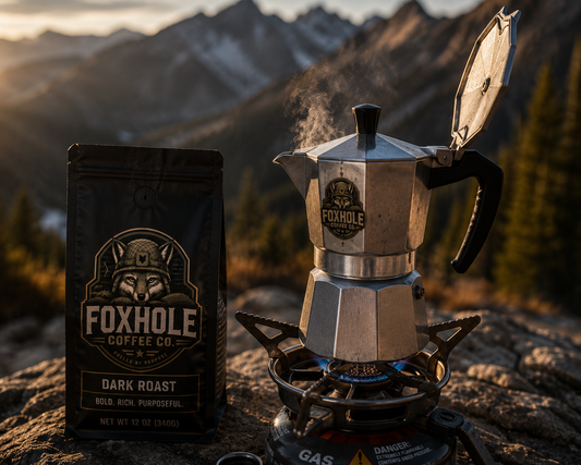 Foxhole Coffee Dark Roast Moka pot brewing on a camp stove with mountain backdrop