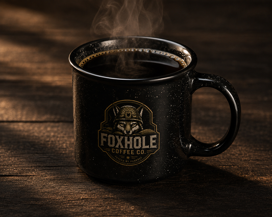 Foxhole Coffee Co. branded black camp mug with steaming black coffee on a dark wood surface